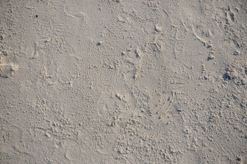 White sand beach texture. Seaside top view photo. Dense sea sand natural texture. Smooth sand surface with step marks.