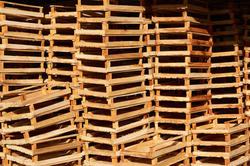 Empty wooden crate for fruits and vegetables stacked in a market warehouse, close-up. Wooden boxes background, outdoors