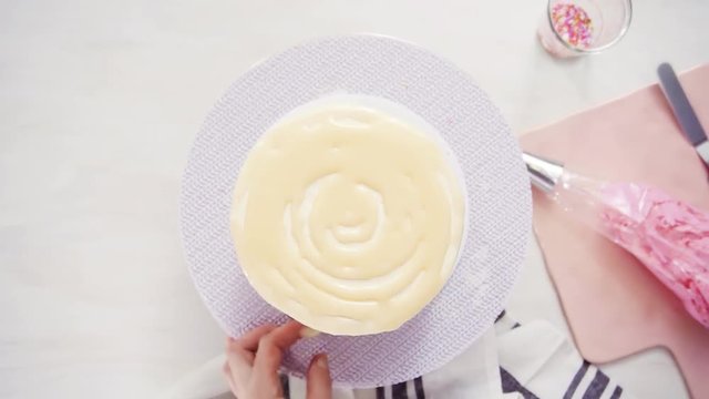 Time lapse. Step by step. Flat lay. Dripping a white chocolate ganache on birthday cake with white buttercream icing