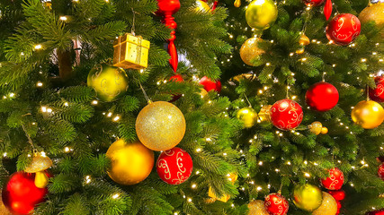 Decorated Christmas tree with red and yellow baubles. Holiday background.