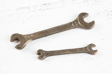 Vintage bronze wrenches on shabby background