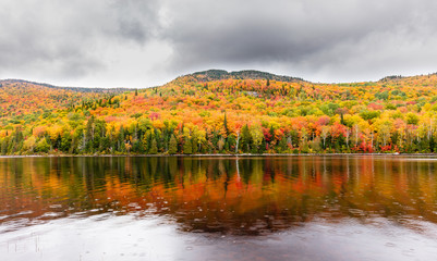 Fall colors of Lac Legault with Mont Kaaikop in the background, in cottage country in the Laurentians, Quebec, Canada.