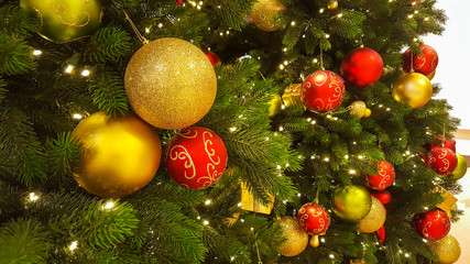 Fototapeta na wymiar Decorated Christmas tree with red and yellow baubles. Holiday background.