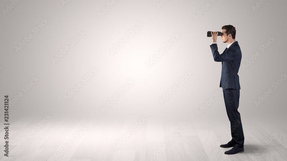 Wall mural businessman looking forward with binoculars in an empty space