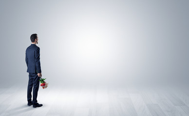 Man standing with his back in an empty room with object in his hand