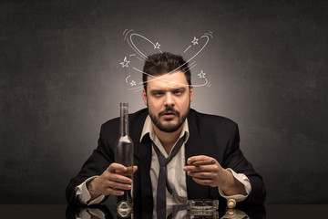 Young drunk man at his office with doodles around
