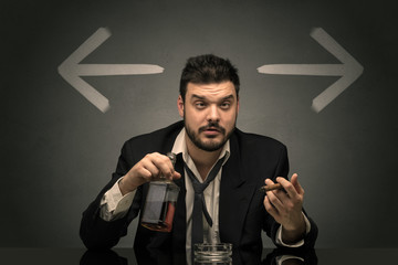 Drunk disappointed man sitting at table with arrows around
