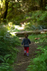 little girl running in the lush green forest