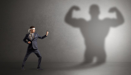 Young karate man fighting with a big black scary shadow
