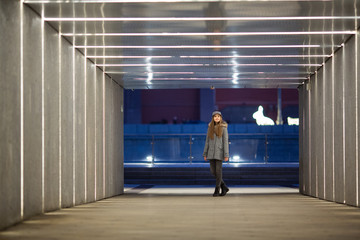 Full-length photo of girl in gray coat standing