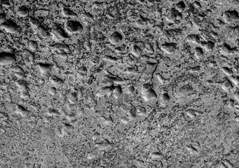 Many rugged holes on the rusty color concrete floor