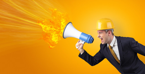 Fototapeta premium Young architect constructor yelling with megaphone with copyspace
