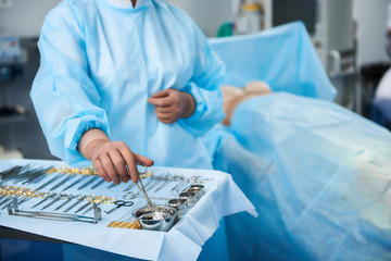 Close up of the medical instruments in the hands of professional surgeon in the operation room