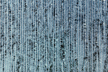 Frosty pattern of hoarfrost and snowflakes on striped glass, winter or Christmas background, texture