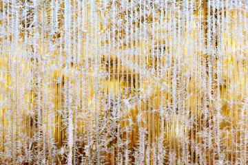Frosty pattern of hoarfrost and snowflakes on striped glass, winter or Christmas background, texture