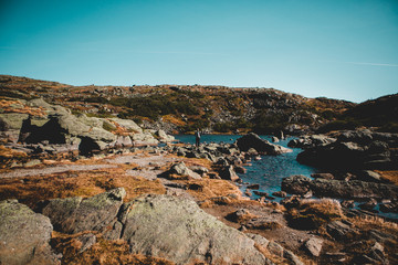 Man Standing at Alpine Lake in Mountains