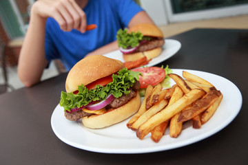 Hamburger and french fries meal at an outdoor cafe