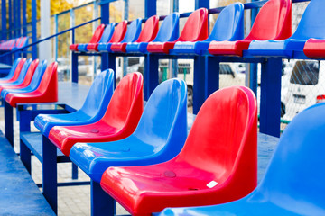 Tribune of fans at the stadium. Empty  blue and red plastic  colored stadium seats. Abstract and Sport concept 