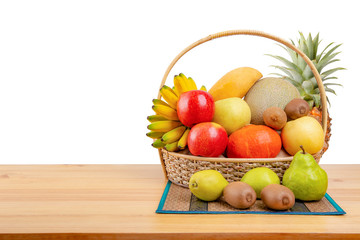 Composition with assorted fruits in wicker basket on wooden table, balanced diet, copy space
