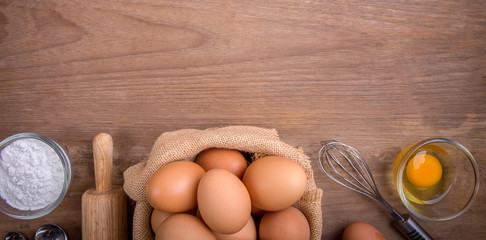 Fresh farm eggs on a wooden rustic background, Whipping eggs and whisk,top view with copy space