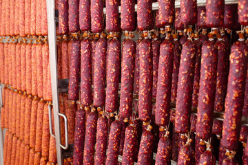 Dried sausage hanging on a rope on a metal frame in the smoke house. Moscow sausage. Braungschwei sausage. Kurkhan.