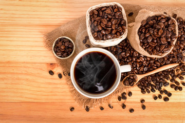 Warm cup of coffee  with beans on burlap sack, with copy space