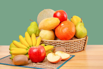 Composition with assorted fruits in wicker basket on wooden table, copy space