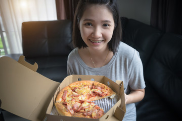 Happy girl eating pizza at home.