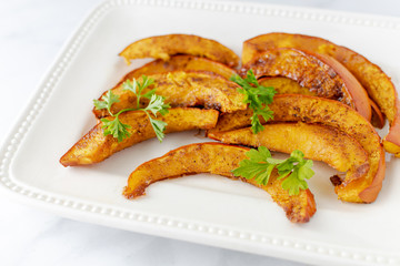 Closeup plate of pumpkin slices with parsley garnish