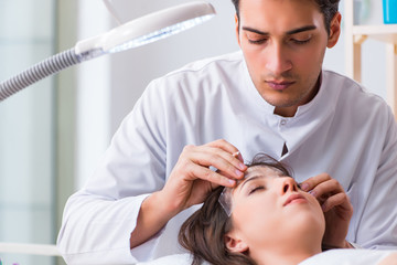 Doctor measuring patient's face before plastic surgery