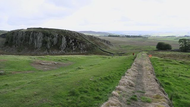 Historic Hadrians Wall rolling hills England Scotland. Hadrian's Wall was a defensive fortification in the Roman province of Britannia built in AD122. One of Britain's ancient tourist attraction.