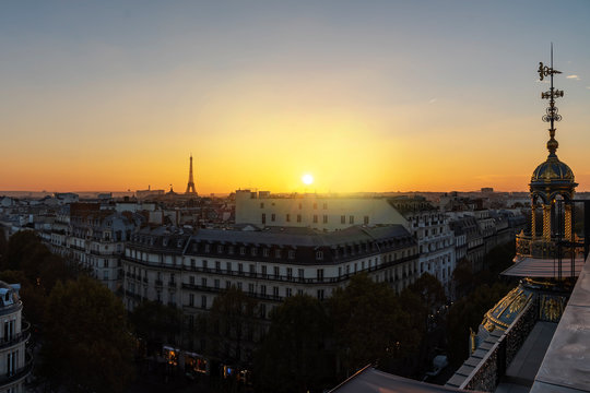 Yellow vivid sunset on Paris roof of ancient stone Victorian buildings with the Eiffel Tower not lit yet, France