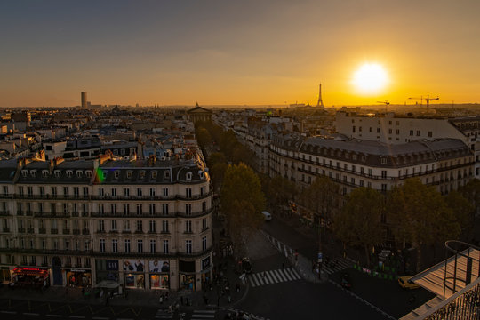 Yellow vivid sunset on Paris roof of ancient stone Victorian buildings with the Eiffel Tower not lit yet, France