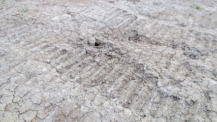 grey dried soil with tire truck track