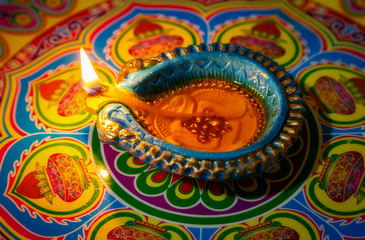 Decorated rangoli design with Diwali traditional clay lamp for festival background