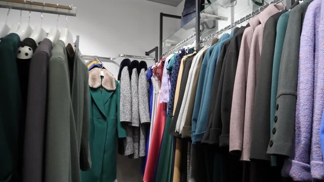 Coats and dress boutique store interior in a shopping mall center with hangers