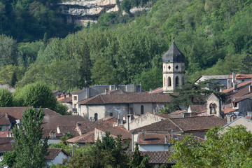 Fototapeta na wymiar View over ancient rooftops in Ariege, France, with spire and forests in background