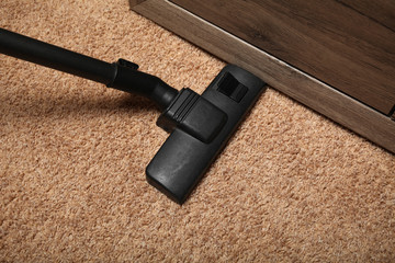 Home cleaning, vacuum cleaner on carpet.