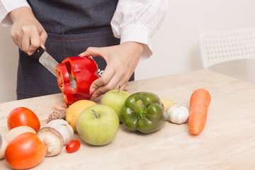 Young Woman Cooking Healthy Food   and Vegetable Salad in the kitchen at home.  Healthy Lifestyle.