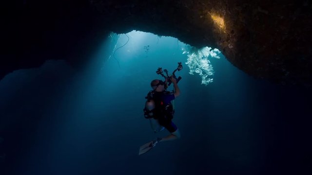 Scuba diver underwater cameraman in cavern