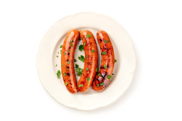 An overhead photo of a plate of fried sausages, shot from above on a white background with a place...
