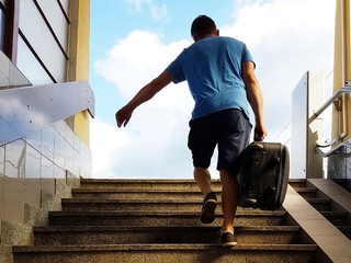 A young guy with a travel suitcase runs up the stairs from the underpass. The thief escapes with stolen carry-on luggage. Catch on transport. Turmoil at the vogal. The path to a better life: freedom