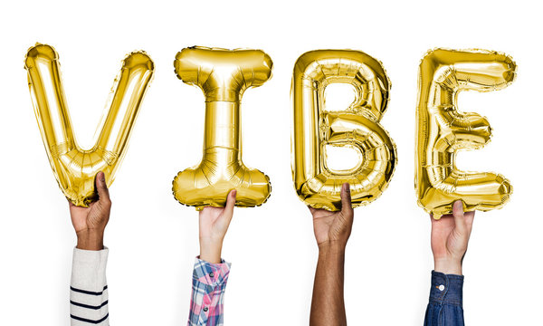 Yellow gold alphabet balloons forming the word vibe