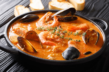 Spanish Suquet de Peix sea soup with potatoes, shrimps, mussels, herbs and fish with picada in a...