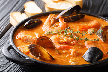 The rich taste of seafood Suquet de Peix soup with potatoes, herbs and fish with the addition of picada close-up in a saucepan. horizontal