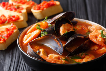 Bouillabaisse soup with seafood and fish close-up in a bowl served with toasts. horizontal