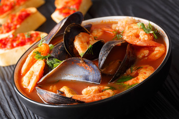 French bouillabaisse fish soup with shrimps, fish fillets and mussels closeup in a bowl. horizontal
