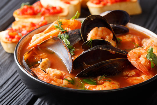 Freshly cooked seafood bouillabaisse soup with shrimps, fish fillets and mussels closeup in a bowl. horizontal