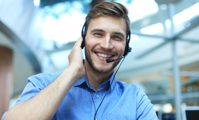 Smiling friendly handsome young male call centre operator.