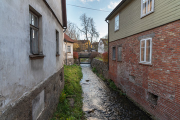 Fototapeta na wymiar Small river between buildings in Kuldiga city, Latvia.